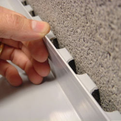 A contractor in Dillon installing a perimeter drain tile system during a sump pump installation.