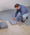 Contractors installing basement subfloor tiles and matting on a concrete basement floor in Conway, South and North Carolina